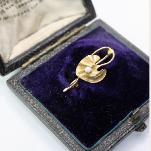 An Art Nouveau gold bar brooch shaped as a lily pad leaf holding a central cream pearl. View III