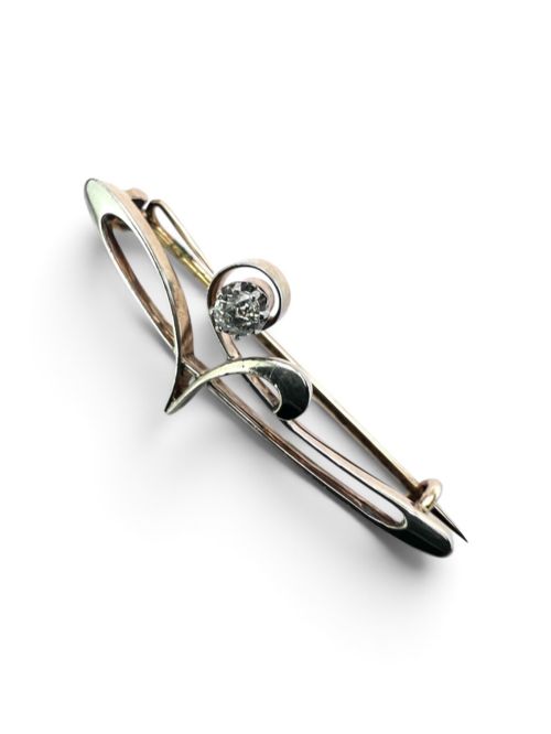 fig 1. An Art Nouveau 15ct gold and platinum brooch featuring a central diamond set within fluid curvilinear metalwork, presented inside a fitted burgundy velvet box.