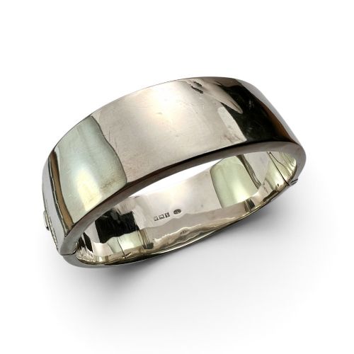 fig 1. A wide sterling silver hinged bangle featuring detailed hand-engraved scrollwork and a polished inner finish.