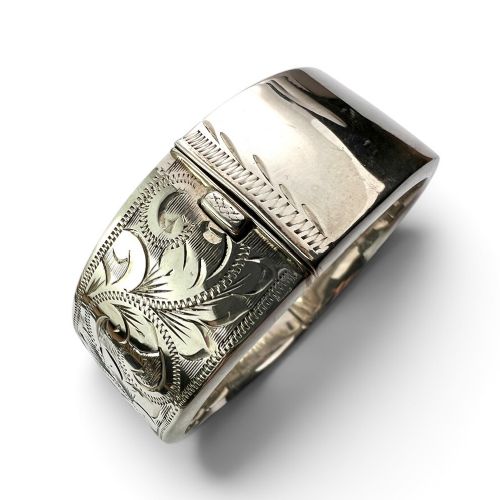 A wide sterling silver hinged bangle featuring detailed hand-engraved scrollwork and a polished inner finish. View III