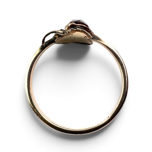 A Victorian 9ct gold ring featuring three deep red garnets arranged in a floral design set upon a slim band. View III