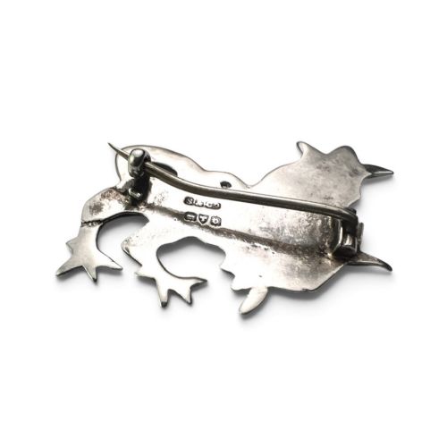 fig 1. A cast sterling silver brooch shaped like a crowned heraldic lion in raised relief.