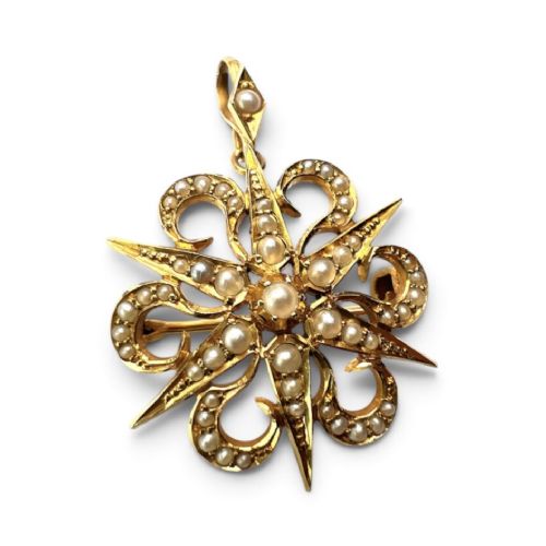 An antique 15ct yellow gold sunburst pendant brooch set with seed pearls arranged in a celestial starburst and scroll motif. View II