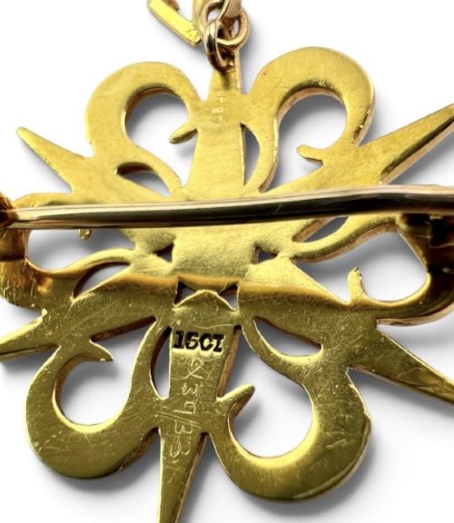 An antique 15ct yellow gold sunburst pendant brooch set with seed pearls arranged in a celestial starburst and scroll motif. View IV
