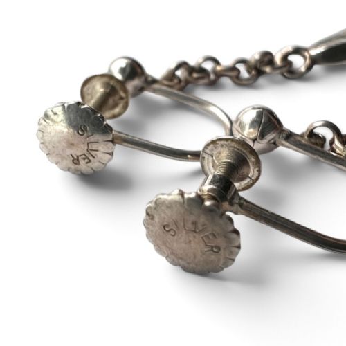 A pair of sterling silver drop earrings featuring screw-back fastenings, chain links, and ribbed lotus bud pendants. View IV