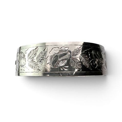 An antique Victorian sterling silver hinged bangle with hand-engraved floral and leaf motifs and interior hallmarks. View VI