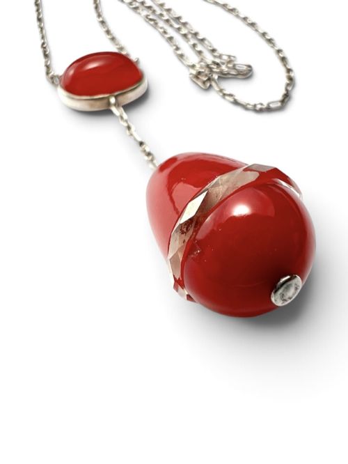 fig 1. An Edwardian silver lavalier necklace featuring an oval red stone cabochon and an egg-shaped red pendant bound by a silver band.