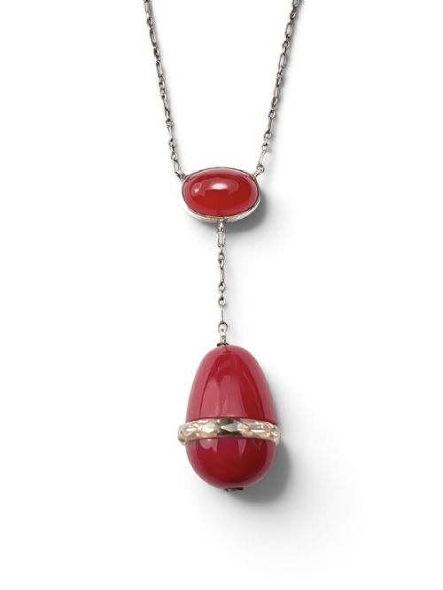 An Edwardian silver lavalier necklace featuring an oval red stone cabochon and an egg-shaped red pendant bound by a silver band. View III