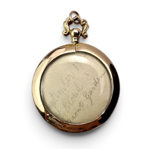fig 1. A circular Edwardian 9ct gold screw-top photo locket with an ornate scroll bail housing a sepia portrait photograph behind glass.