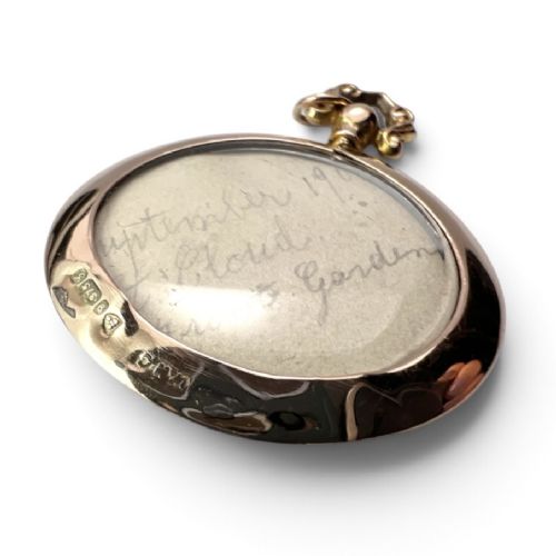 A circular Edwardian 9ct gold screw-top photo locket with an ornate scroll bail housing a sepia portrait photograph behind glass. View III