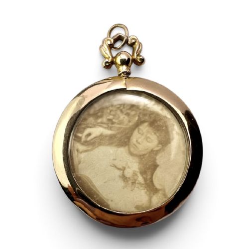 A circular Edwardian 9ct gold screw-top photo locket with an ornate scroll bail housing a sepia portrait photograph behind glass. View IV