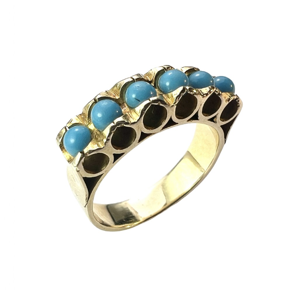 An 18ct yellow gold modernist ring set with six round turquoise cabochons within a textured openwork gallery.