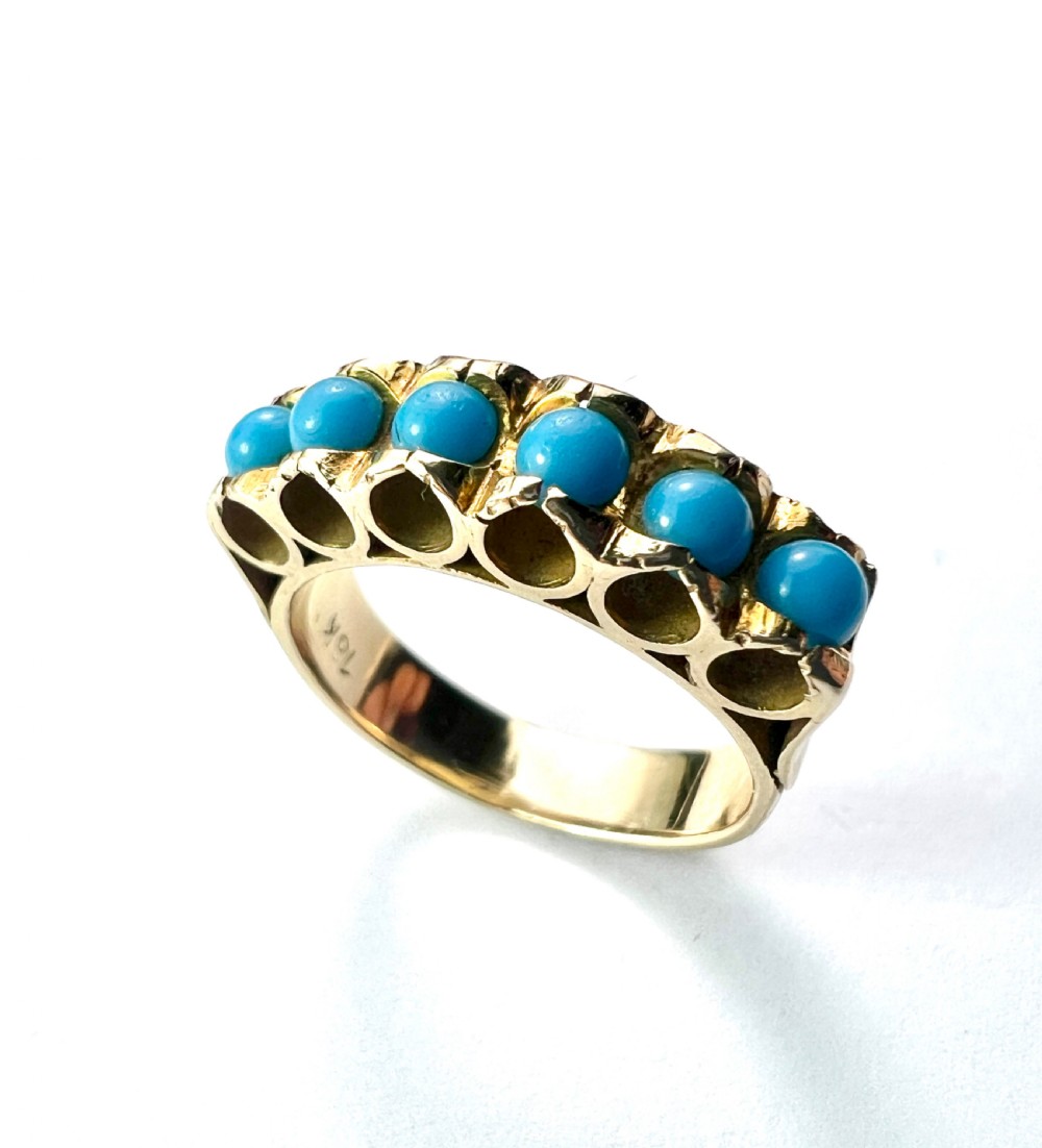 An 18ct yellow gold modernist ring set with six round turquoise cabochons within a textured openwork gallery. View V