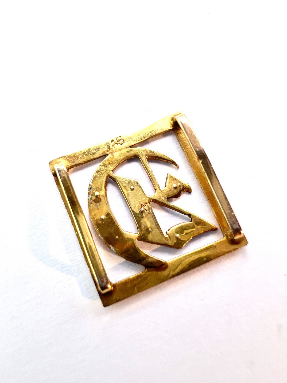 A square 9ct yellow gold Victorian ribbon slider pendant featuring a gothic letter E set with seed pearls. View IV