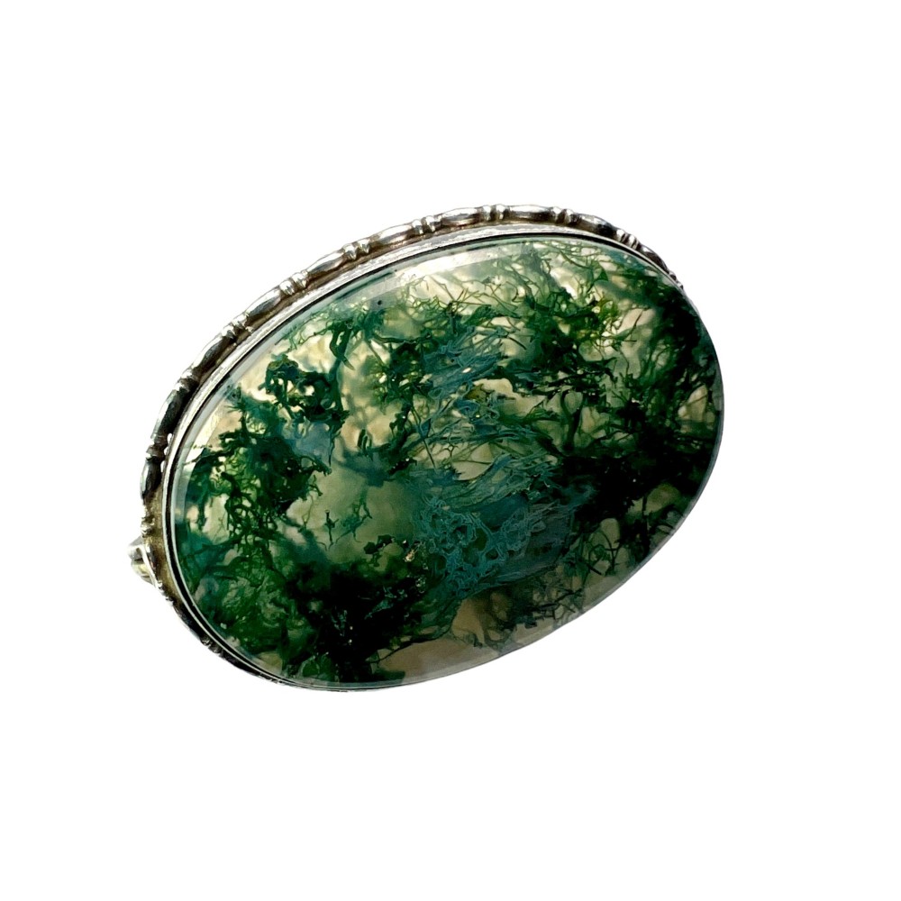 An oval antique sterling silver brooch featuring a translucent moss agate cabochon with green dendritic inclusions within an engraved bezel frame. View II