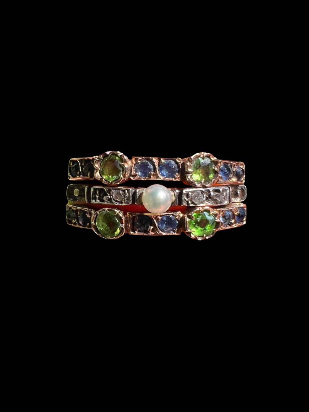 An Edwardian multi-band harem ring crafted in gold and silver, set with green and blue gemstones, diamonds, and a central pearl. View II