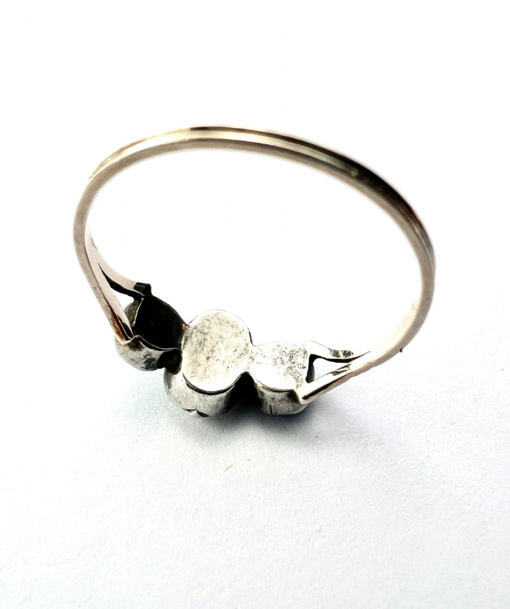A Georgian three-stone ring featuring a central oval clear paste stone flanked by two blue cushion-cut paste stones set in silver and gold. View VII
