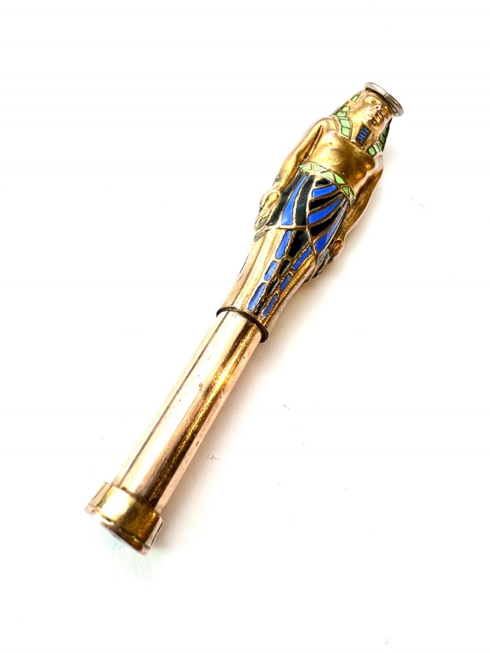 An antique gilt metal and enamel Egyptian Revival sarcophagus pendant featuring a pharaoh figure with blue and green enamelled detailing, designed as a mechanical propelling pencil. View IV