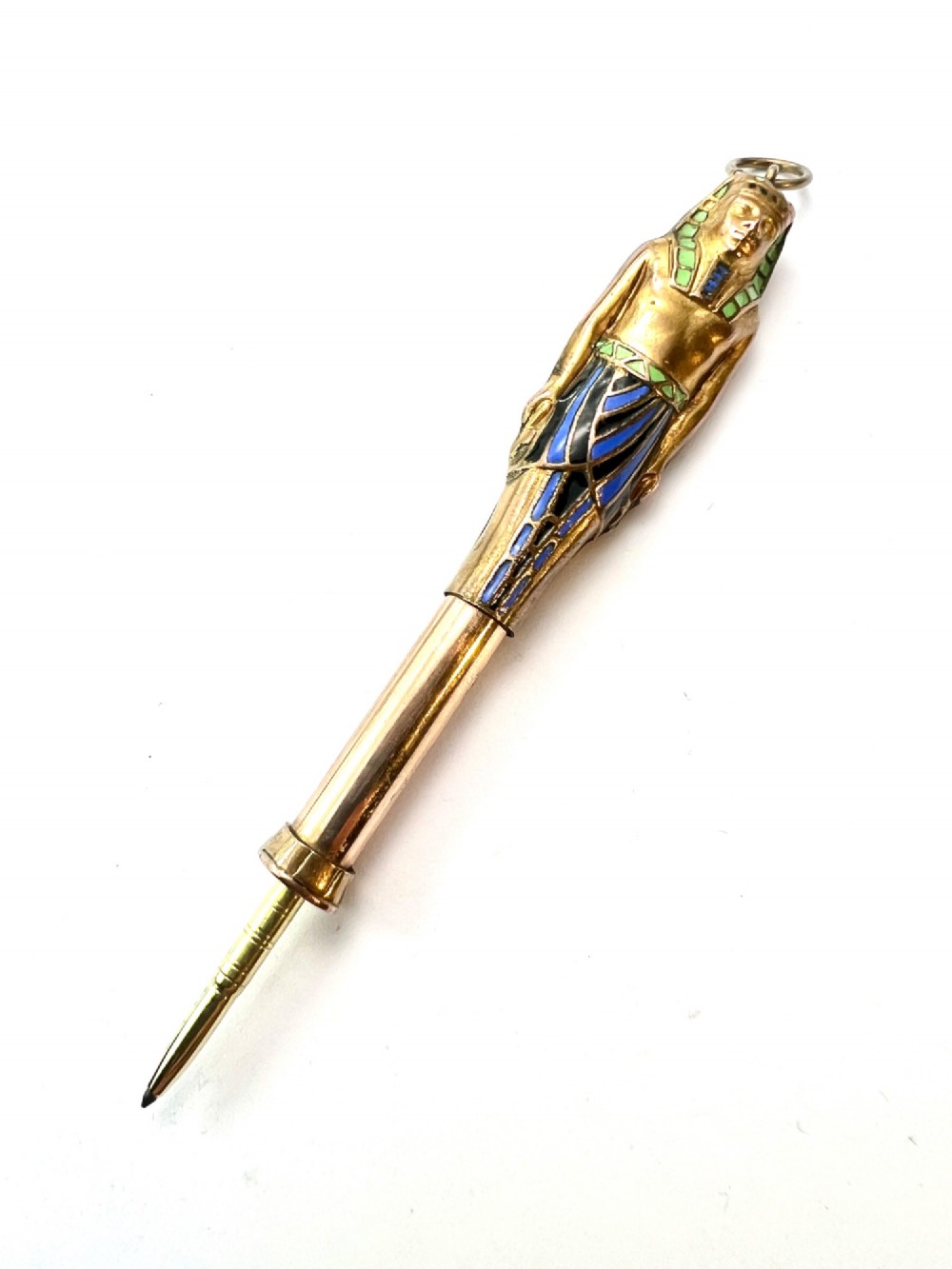 An antique gilt metal and enamel Egyptian Revival sarcophagus pendant featuring a pharaoh figure with blue and green enamelled detailing, designed as a mechanical propelling pencil. View V