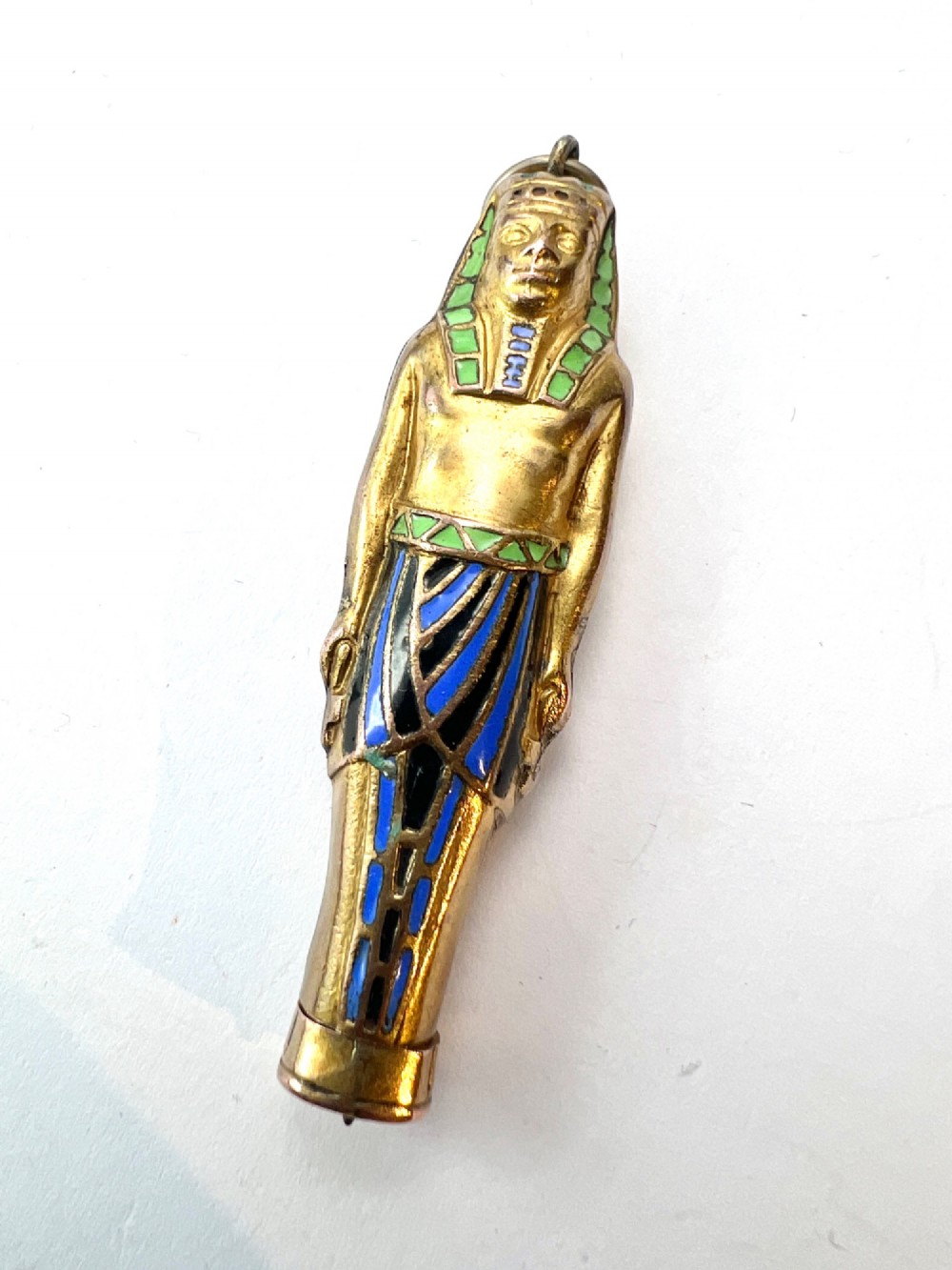 An antique gilt metal and enamel Egyptian Revival sarcophagus pendant featuring a pharaoh figure with blue and green enamelled detailing, designed as a mechanical propelling pencil. View VII
