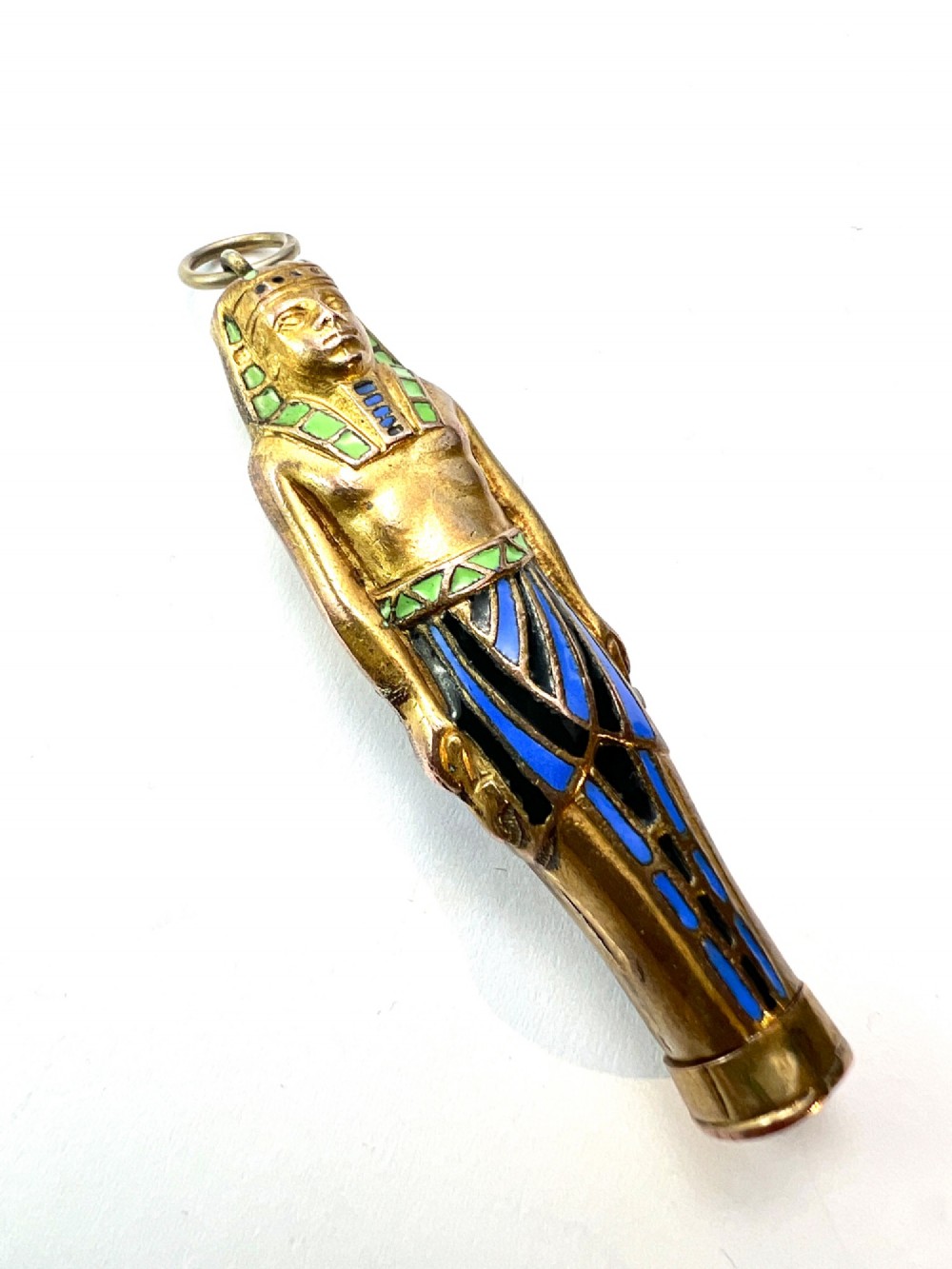 An antique gilt metal and enamel Egyptian Revival sarcophagus pendant featuring a pharaoh figure with blue and green enamelled detailing, designed as a mechanical propelling pencil. View VIII