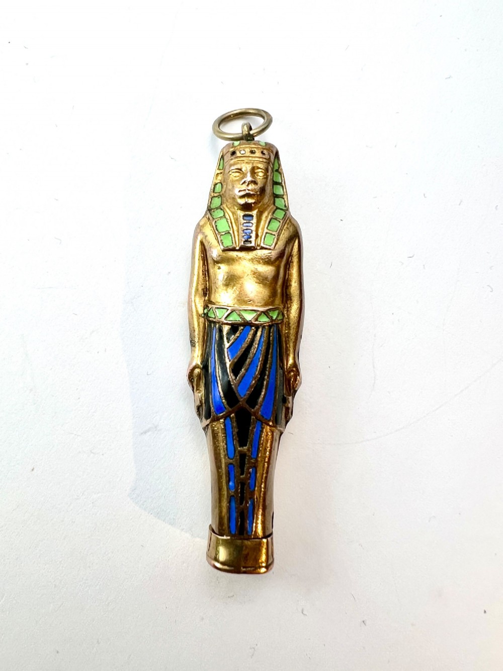 An antique gilt metal and enamel Egyptian Revival sarcophagus pendant featuring a pharaoh figure with blue and green enamelled detailing, designed as a mechanical propelling pencil. View IX