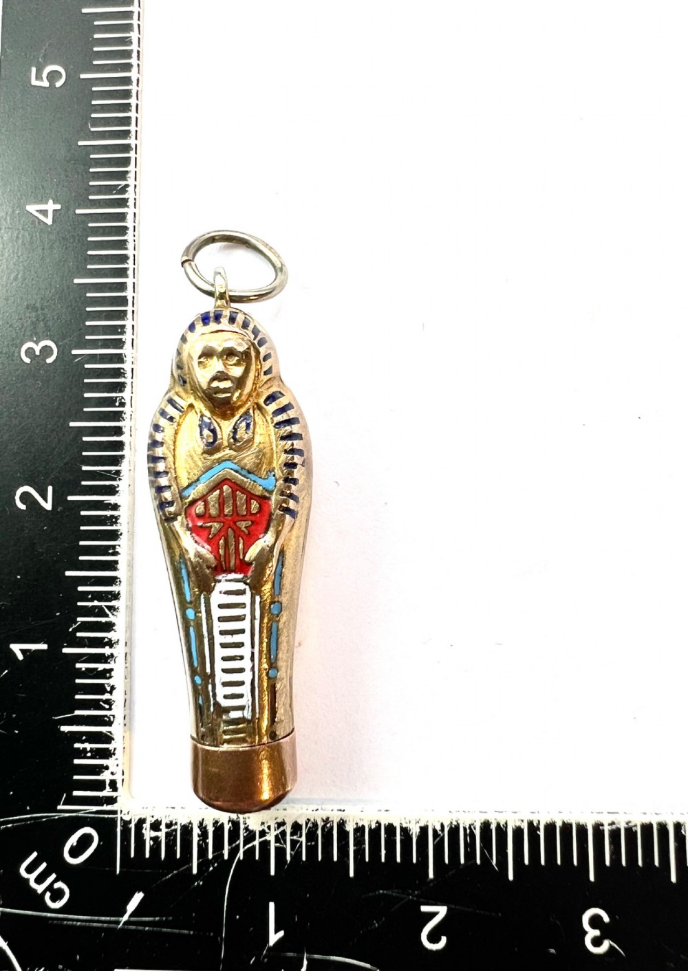 An antique gilt metal sarcophagus-shaped propelling pencil pendant featuring colourful blue, red, and white enamel decoration with a top jump ring. View VII