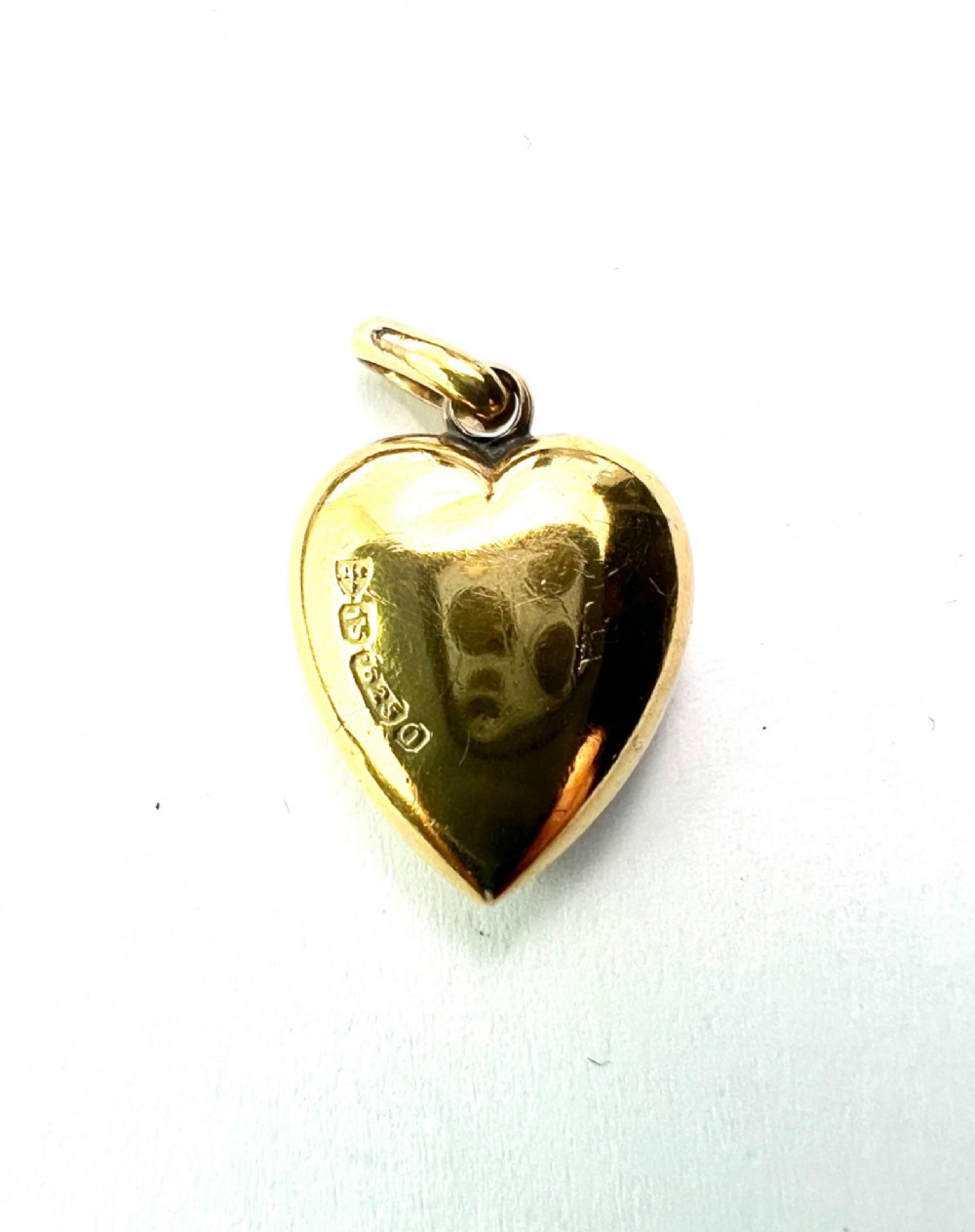A late Victorian 15ct yellow gold puffed heart pendant featuring a central starburst engraving inset with a small diamond. View III