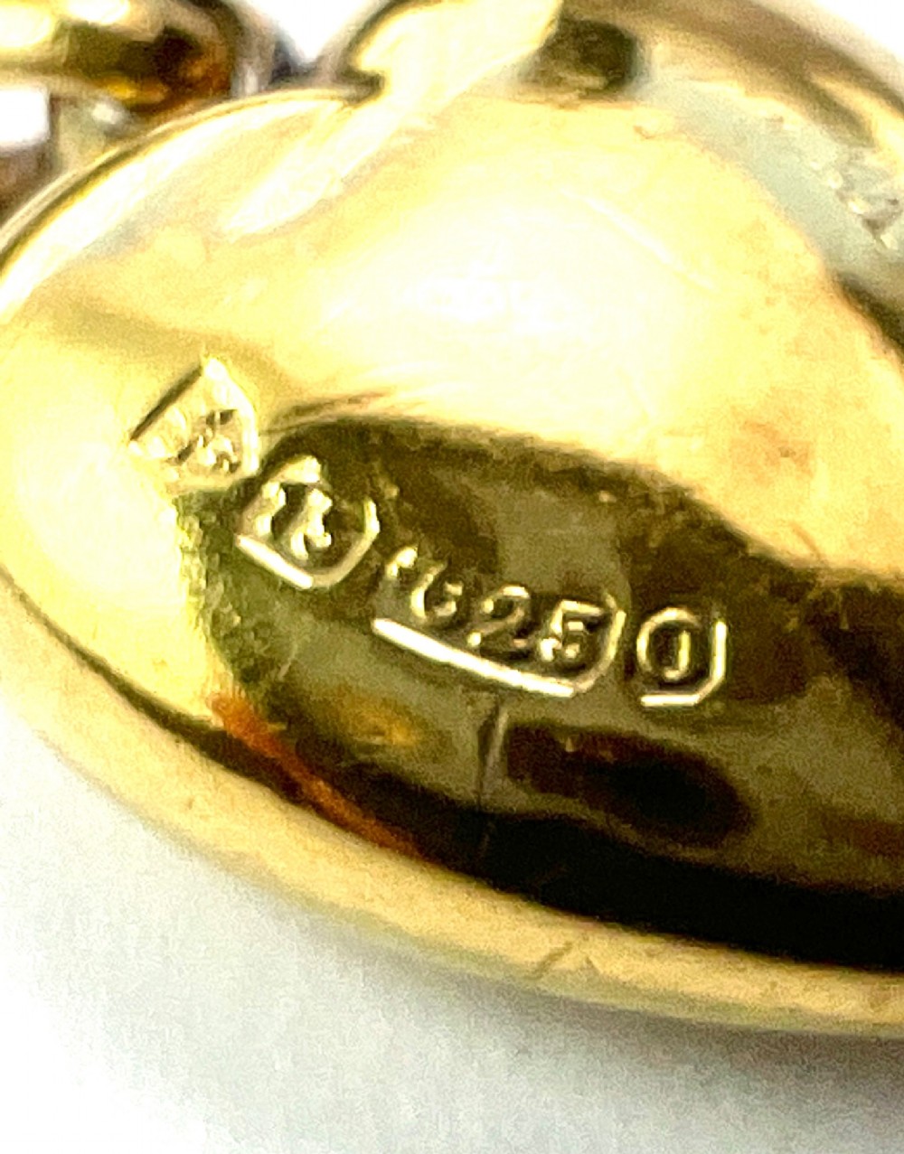 A late Victorian 15ct yellow gold puffed heart pendant featuring a central starburst engraving inset with a small diamond. View V