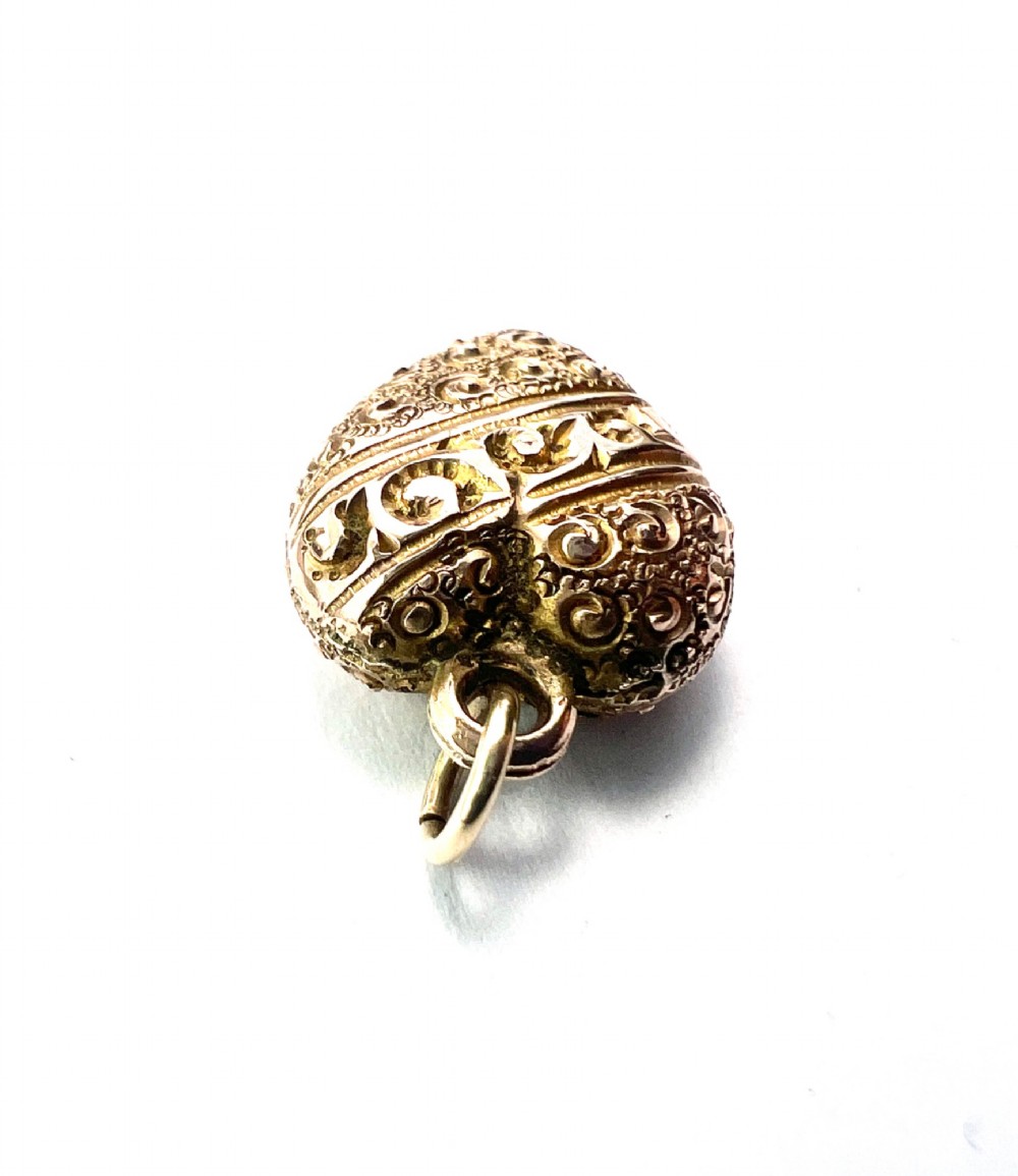 A three-dimensional 9ct gold Victorian heart pendant featuring intricate chased scrollwork and a top suspension ring. View IV