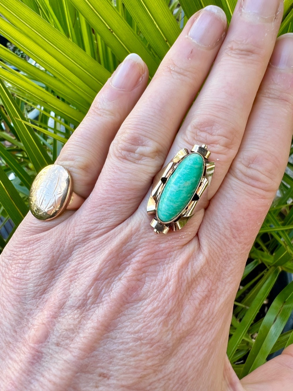 A 1940s gold cocktail ring featuring an elongated green aventurine cabochon set within sculptural scrolled side accents. View VIII