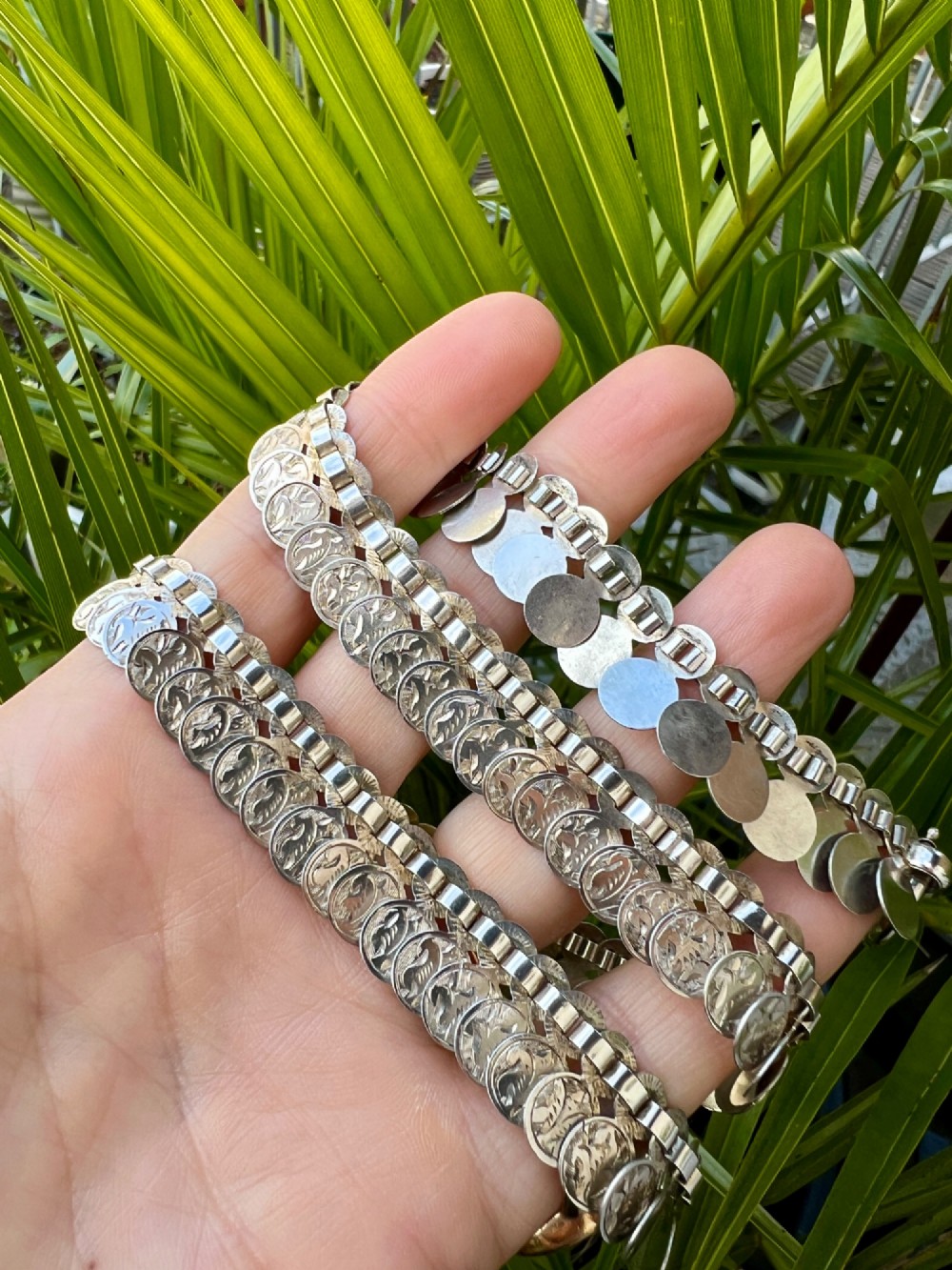 A coiled Victorian sterling silver chain decorated with overlapping, hand-engraved circular coin discs and secured with a traditional bolt ring clasp. View VIII