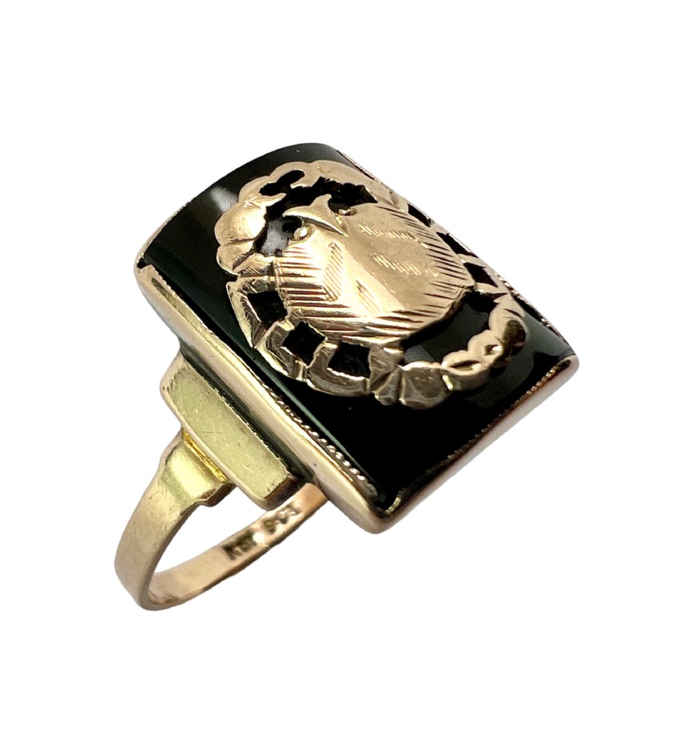 A rectangular 9ct gold ring set with a flat black onyx plaque featuring an detailed gold crab motif for the Cancer zodiac sign. View VII