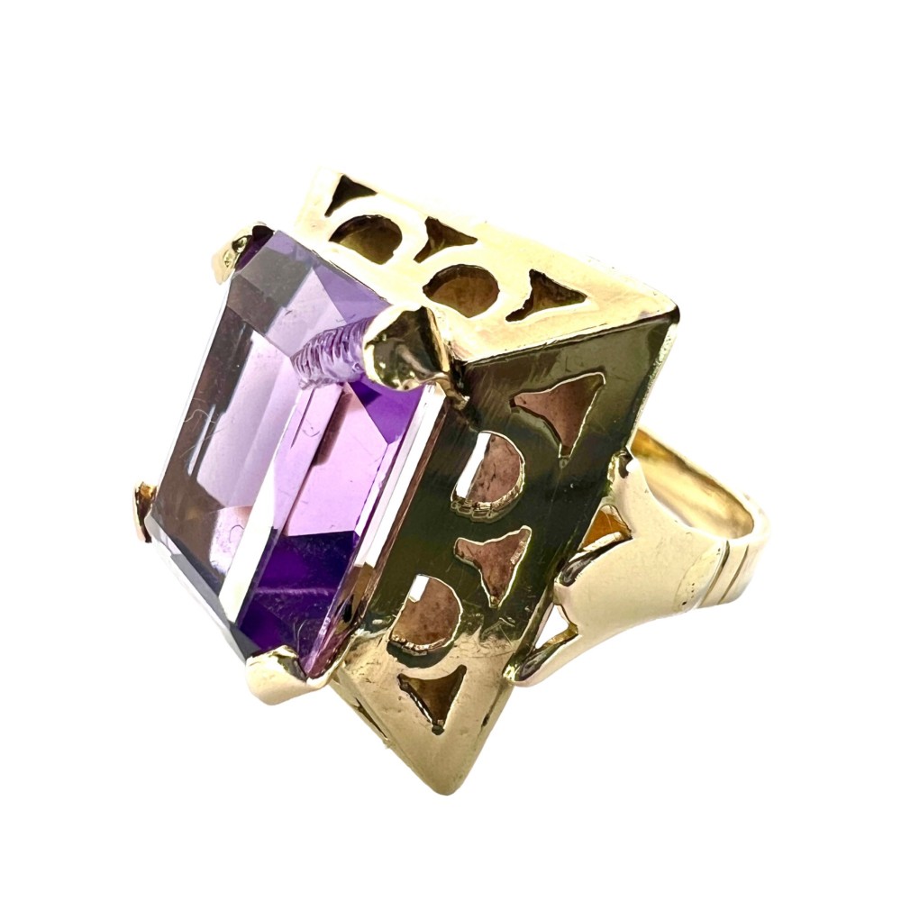A vintage 14-carat yellow gold cocktail ring featuring a rectangular emerald-cut amethyst set in a raised geometric openwork gallery.