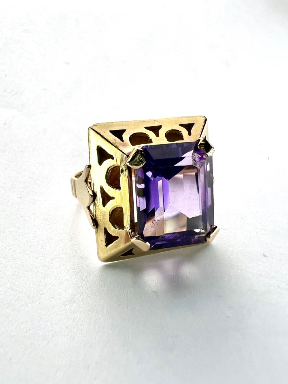 A vintage 14-carat yellow gold cocktail ring featuring a rectangular emerald-cut amethyst set in a raised geometric openwork gallery. View III