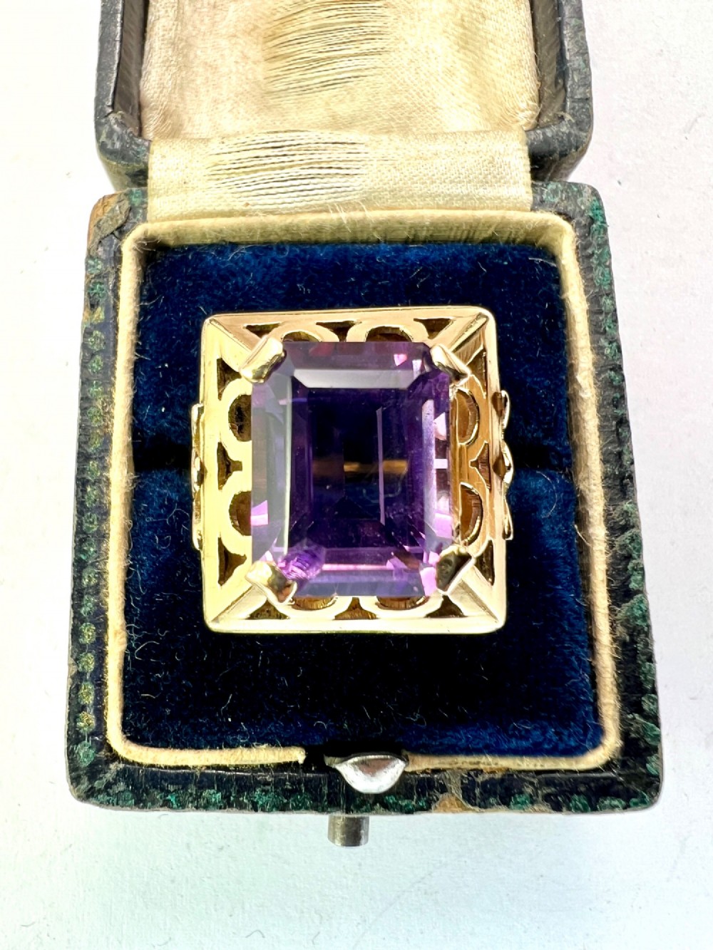 A vintage 14-carat yellow gold cocktail ring featuring a rectangular emerald-cut amethyst set in a raised geometric openwork gallery. View VI