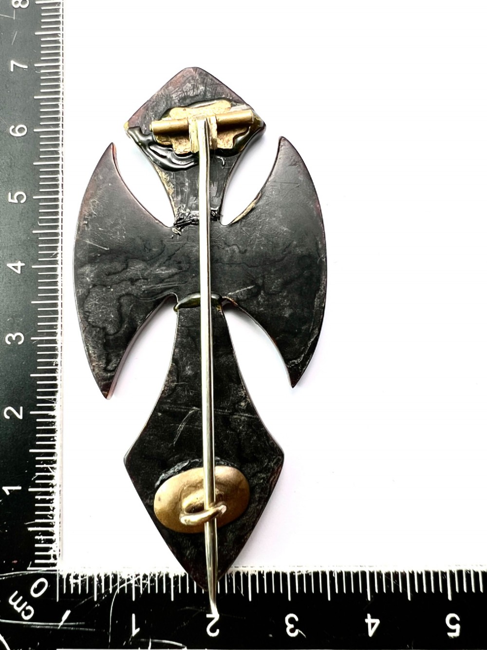 A Victorian cross brooch crafted from dark tortoiseshell with gold and silver pique floral inlays. View V