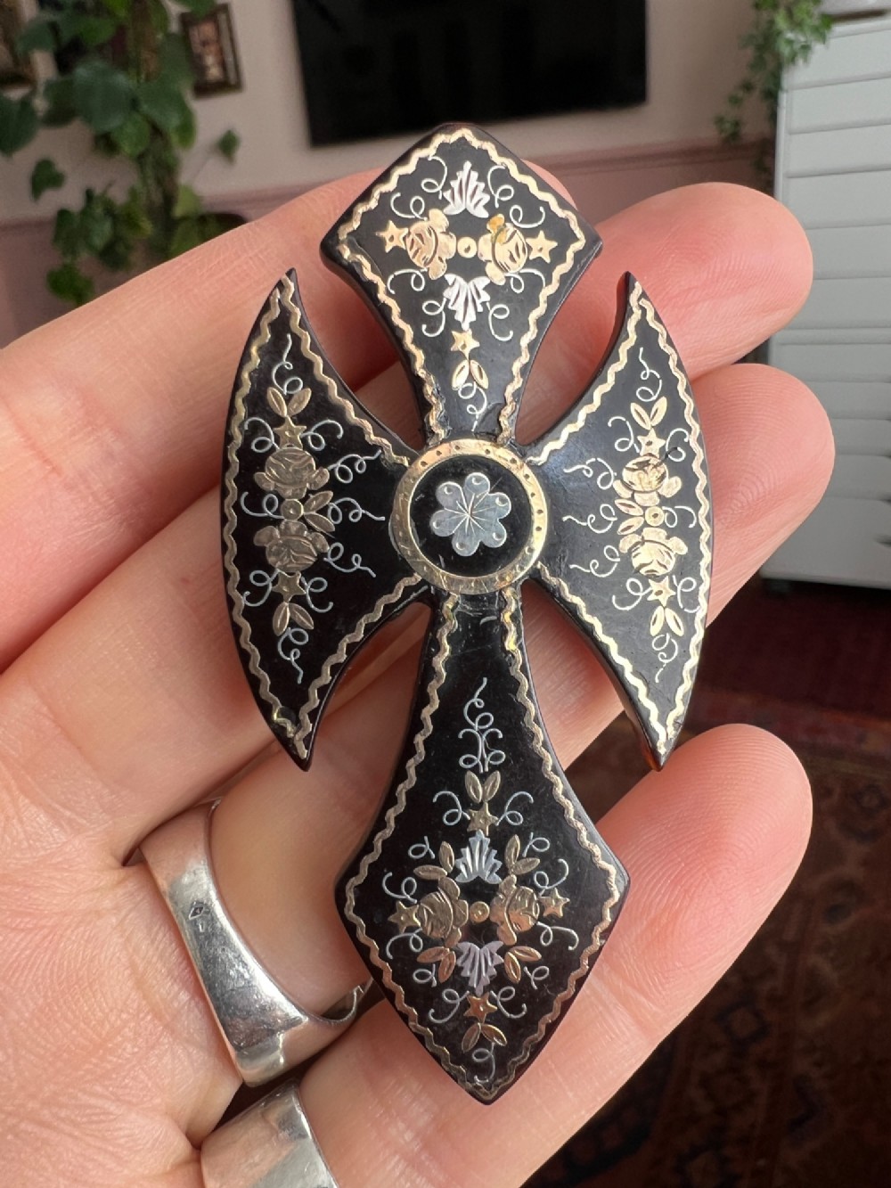 A Victorian cross brooch crafted from dark tortoiseshell with gold and silver pique floral inlays. View VI