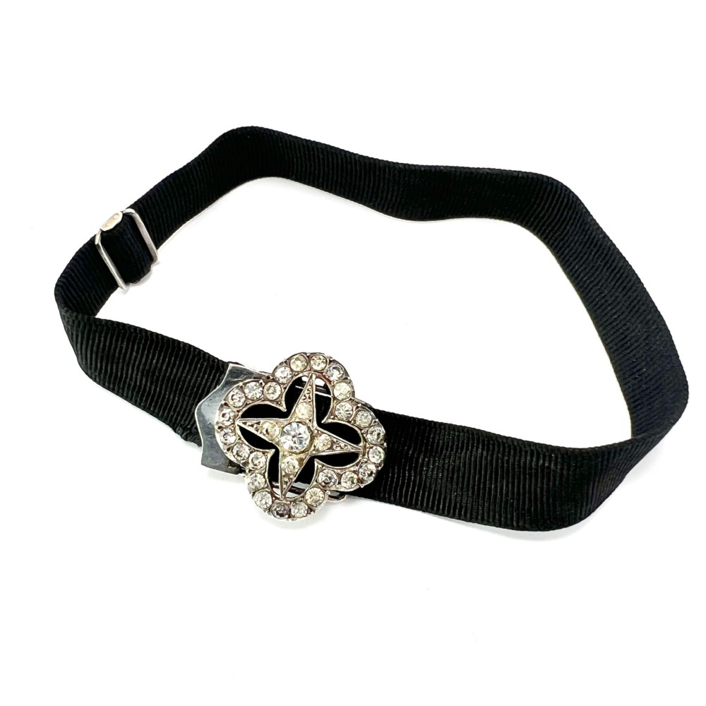 An antique silver ribbon slider bracelet featuring a star-shaped paste central motif on a black grosgrain ribbon. View II