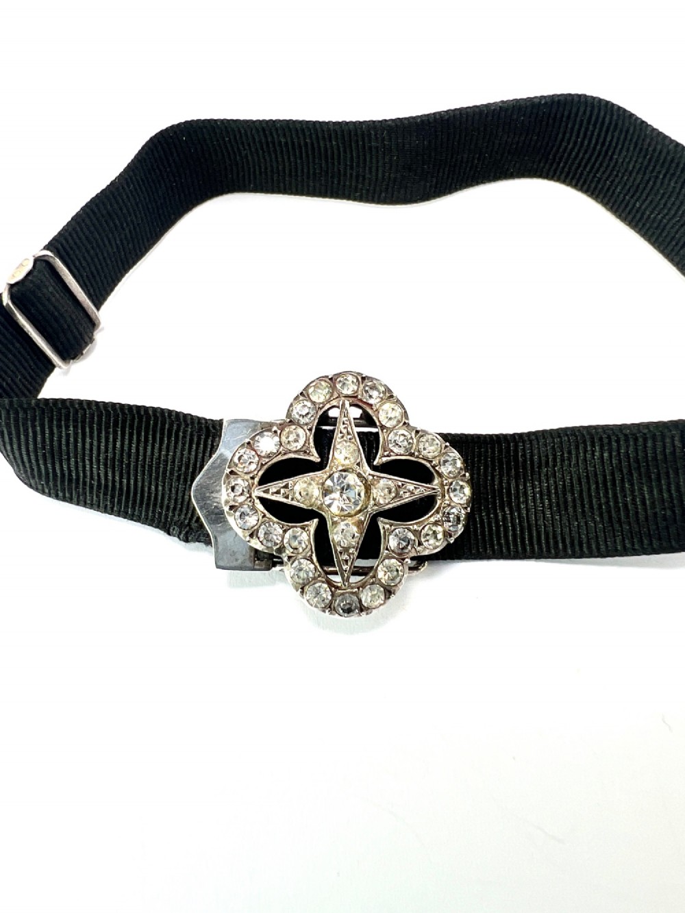 An antique silver ribbon slider bracelet featuring a star-shaped paste central motif on a black grosgrain ribbon. View VI
