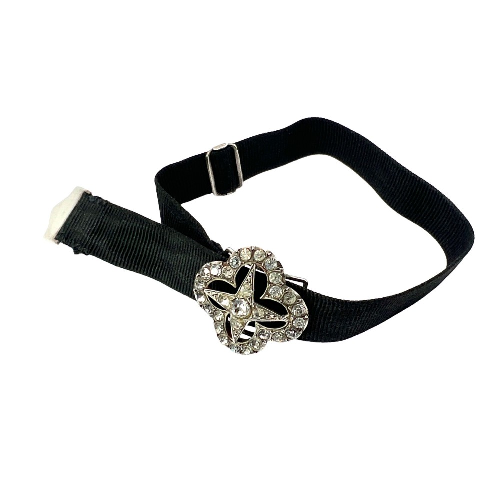 An antique silver ribbon slider bracelet featuring a star-shaped paste central motif on a black grosgrain ribbon. View VII