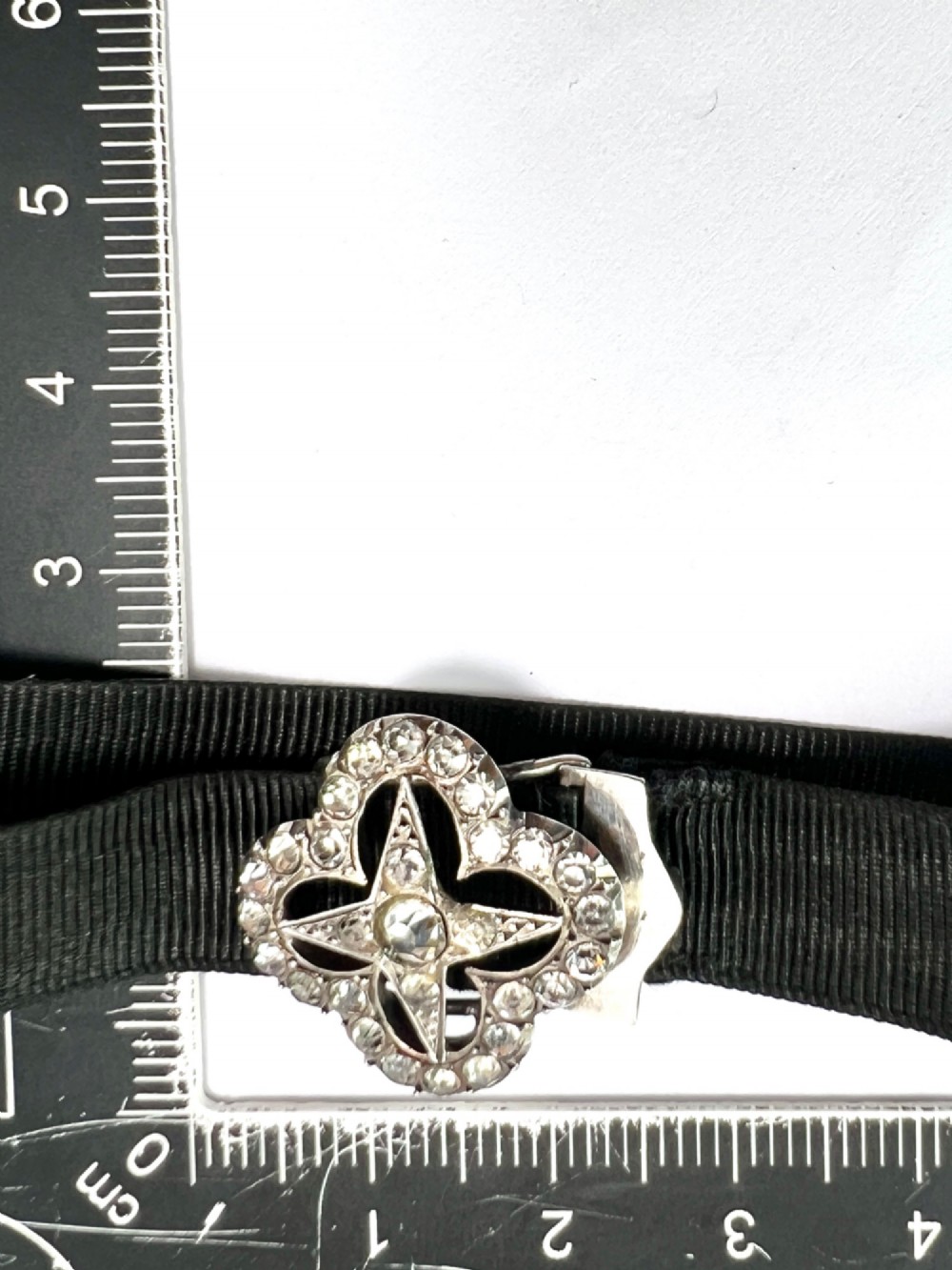 An antique silver ribbon slider bracelet featuring a star-shaped paste central motif on a black grosgrain ribbon. View VIII