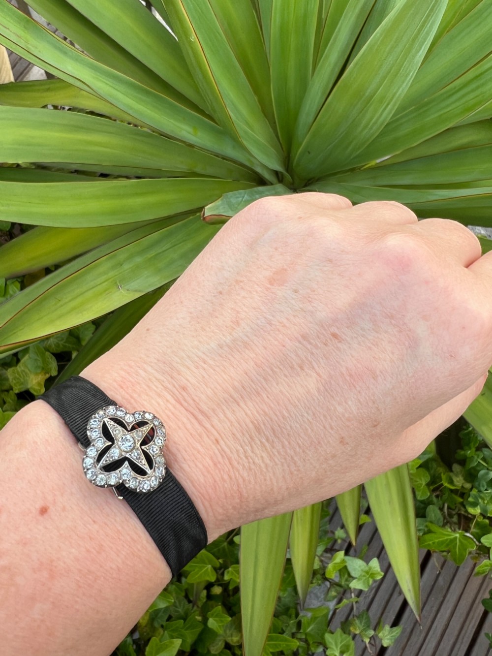 An antique silver ribbon slider bracelet featuring a star-shaped paste central motif on a black grosgrain ribbon. View IX
