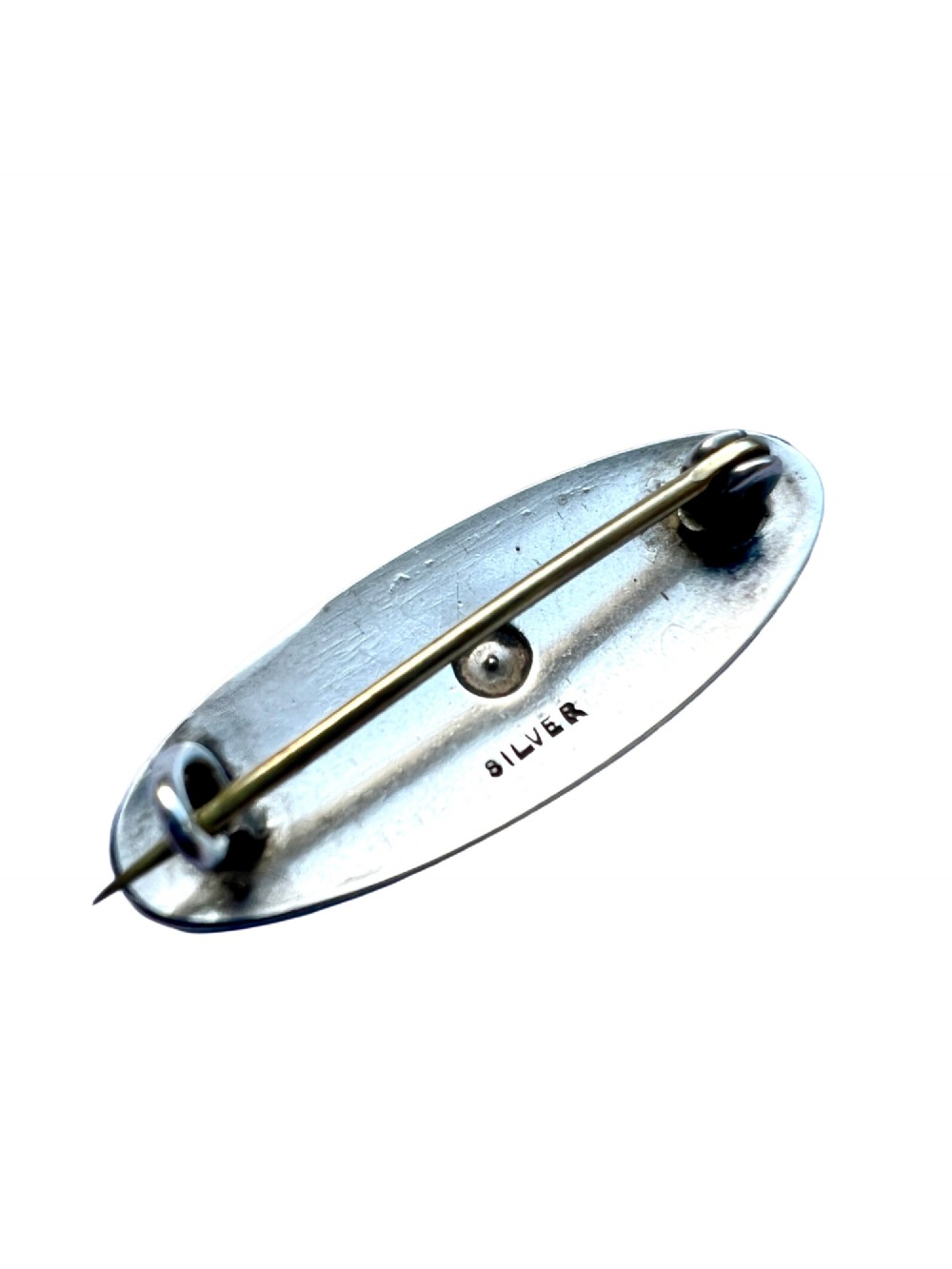 An oval Art Deco brooch featuring black enamel inlay with silver scroll linework and a central clear glass paste stone. View III