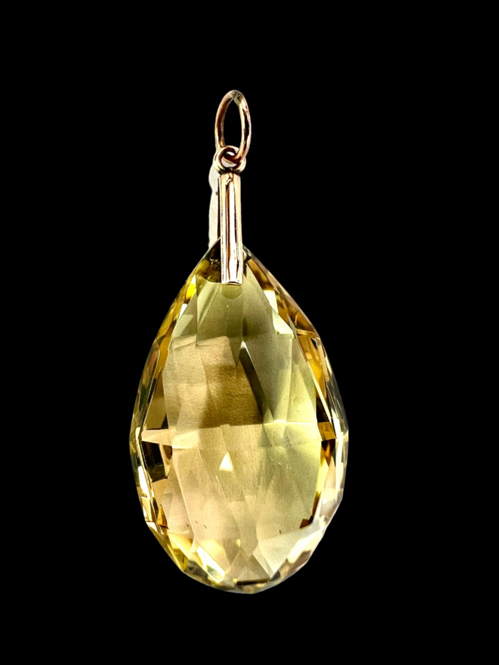 A faceted teardrop-cut yellow citrine gemstone attached to a simple 9ct gold bail stamped with hallmarks. View II
