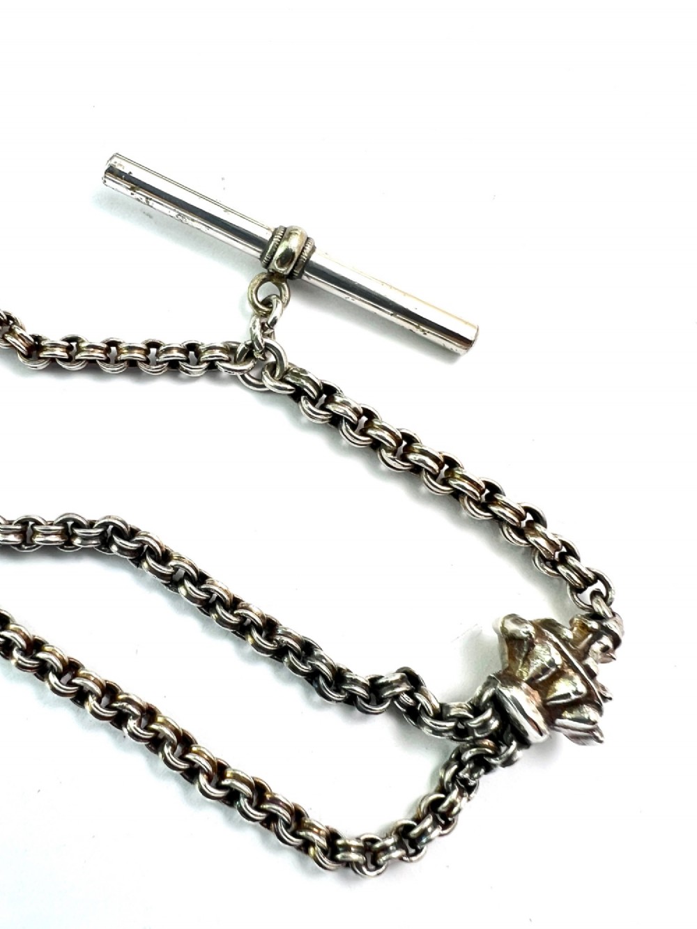 An antique silver Albertina watch chain featuring woven multi-strand links, a T-bar attachment, decorative sliding motifs, a swivel clasp, and a hanging tassel fob. View IV