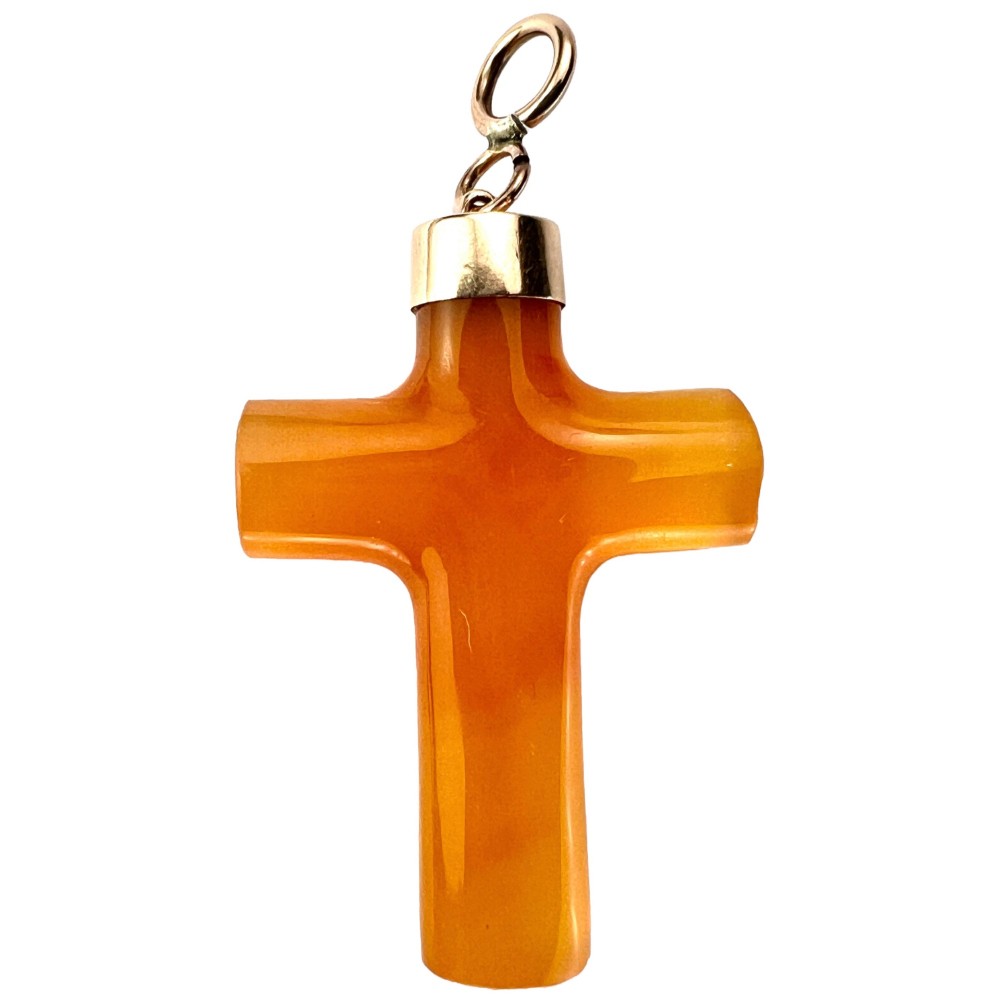 A carved translucent amber agate cross pendant featuring a polished gold cap and suspension bail.