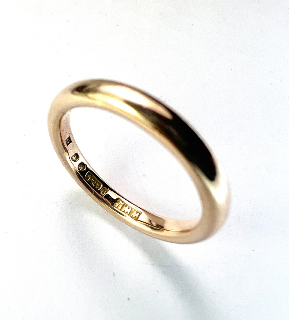 A smooth plain 9ct gold ring displaying visible official hallmarks stamped on the interior band.
