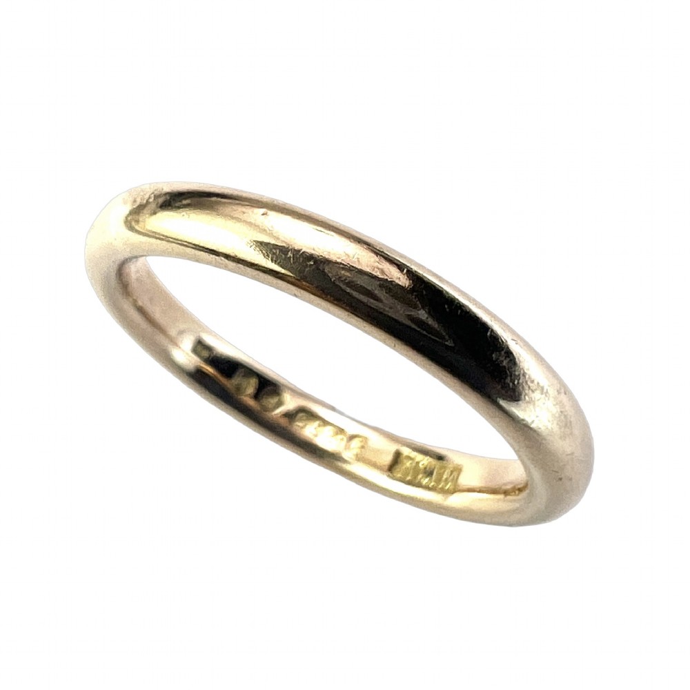 A smooth plain 9ct gold ring displaying visible official hallmarks stamped on the interior band. View II