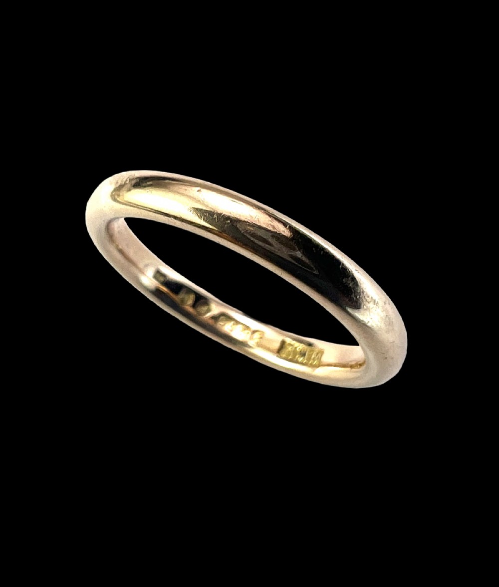 A smooth plain 9ct gold ring displaying visible official hallmarks stamped on the interior band. View III